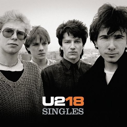 Black-and-white photo of the band U2 with four members standing outdoors, with the text "U2 18 SINGLES" at the bottom.