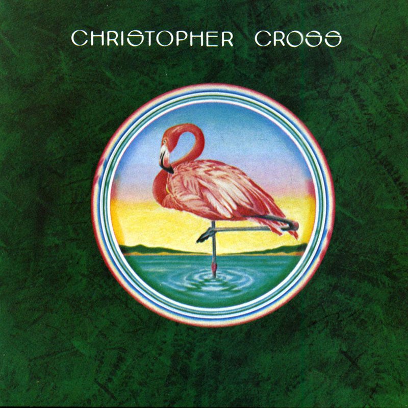 Album cover featuring a pink flamingo standing on one leg in a body of water with a yellow and pink sunset in the background, surrounded by a multi-colored circular border, with the text 'Christopher Cross' at the top.