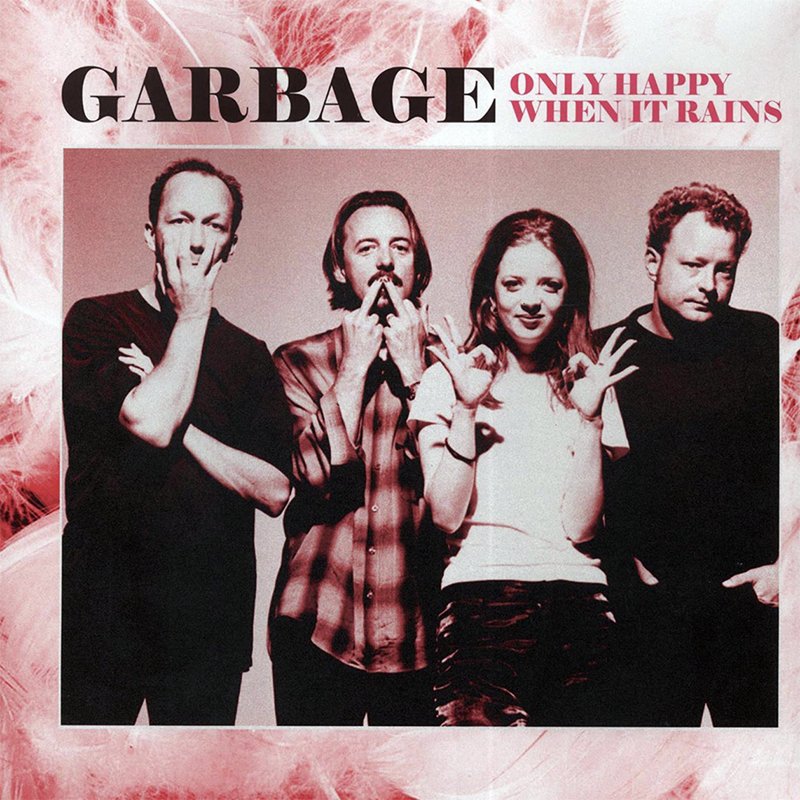 An album cover for the band Garbage titled "Only Happy When It Rains," featuring four band members striking various poses against a pink, fluffy background.