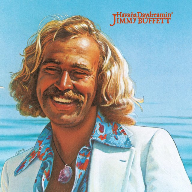 An illustrated portrait of Jimmy Buffett smiling with long blonde hair and a mustache, wearing a white blazer and a colorful shirt, with the ocean in the background. Text reads 'Havana Daydreamin' Jimmy Buffett' in the top right corner.