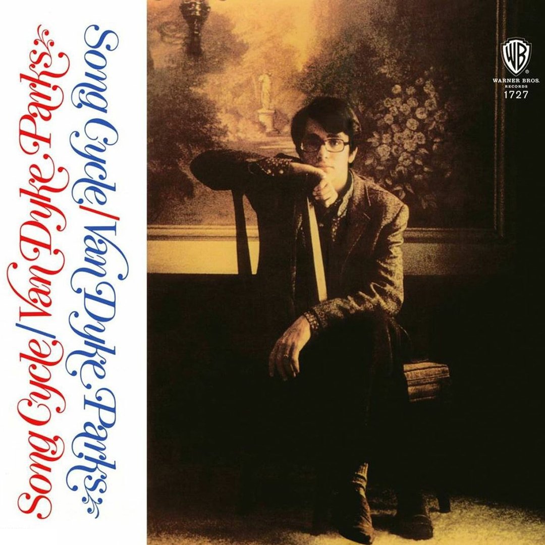 Album cover with a sepia-toned photo of a young man with dark hair and glasses sitting in front of a landscape painting, wearing a blazer and pointing towards the camera. The left side of the cover has stylized red and blue text that reads "Some Cycles" by Van Dyke Parks. The top right corner displays the Warner Bros. Records logo with the catalog number 1727.